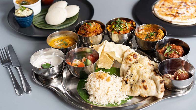 A traditional thali with curries, idli and naan